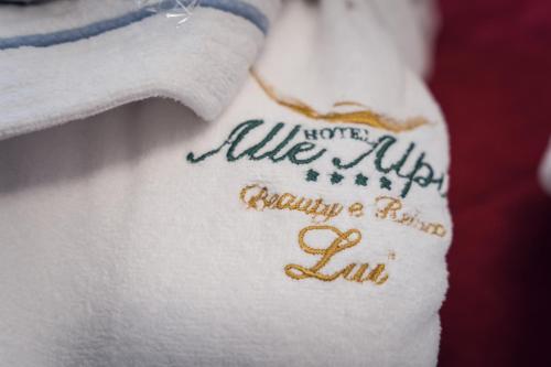 a towel with the words alice inka on it at Hotel Alle Alpi in Moena