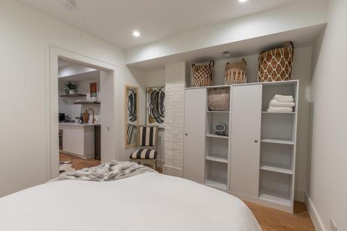 a bedroom with a white bed and shelves at Delightful Apt in the Heart of Dupont in Washington, D.C.