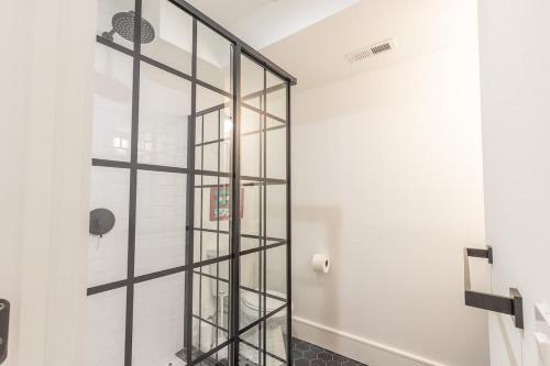 a glass shower door in a bathroom with white walls at Delightful Apt in the Heart of Dupont in Washington, D.C.