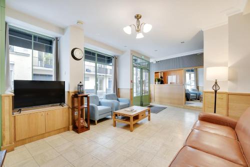 a living room with a flat screen tv at Hotel de l'Europe in Paris