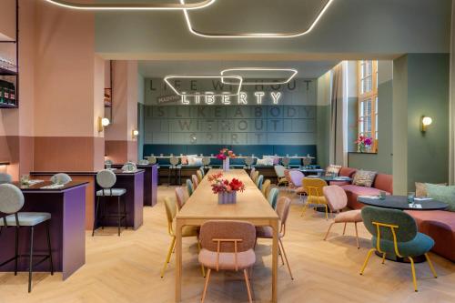 a restaurant with tables and chairs and a waiting room at The Rebyl, Nijmegen, a Tribute Portfolio Hotel in Nijmegen