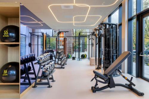 a gym with cardio equipment and treadmills at The Rebyl, Nijmegen, a Tribute Portfolio Hotel in Nijmegen