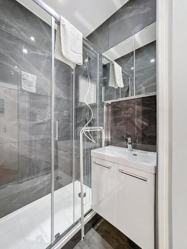 une salle de bain blanche avec une douche et un lavabo dans l'établissement My Home Saint Jérôme 1, à Lyon