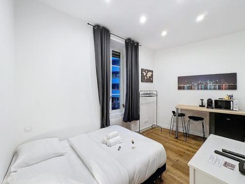 een witte slaapkamer met een wit bed en een bureau bij My Home Saint Jérôme 1 in Lyon