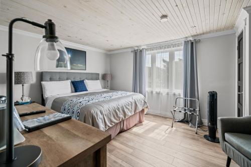 a bedroom with a bed and a desk and a bed sidx sidx sidx at Edge of the Avalon Inn in Trepassey