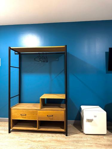 a room with a blue wall with a wooden shelf at English House in Bistriţa