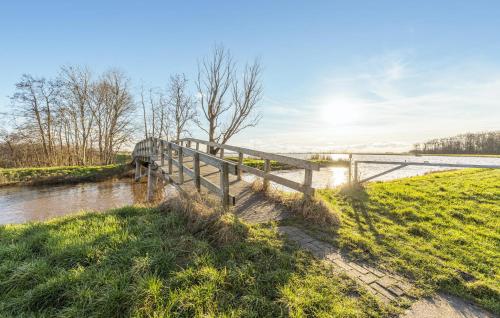 a wooden bridge over a river next to a field at 3 Bedroom Lovely Home In Wagenborgen in Wagenborgen