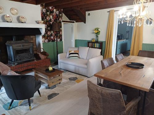 a living room with a table and a fireplace at GITE LA BELLE St FLI in Saint-Félix