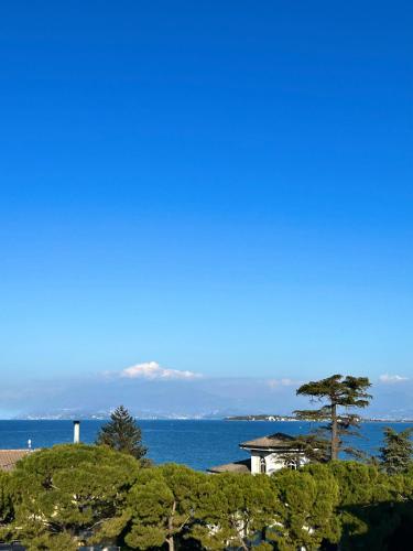a view of the ocean and a house with a tree at Hotel Piccola Vela in Desenzano del Garda