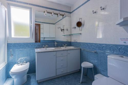 a bathroom with a toilet and a sink and a mirror at Villa Silvina - Close to the Beach in Son Bou
