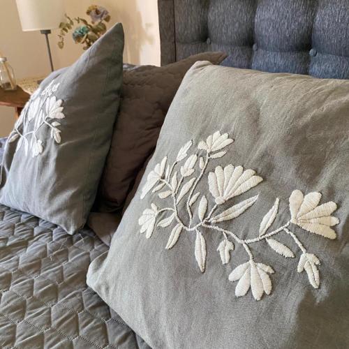 a bed with two pillows with a floral pattern on it at Sayani Posada in Chilecito