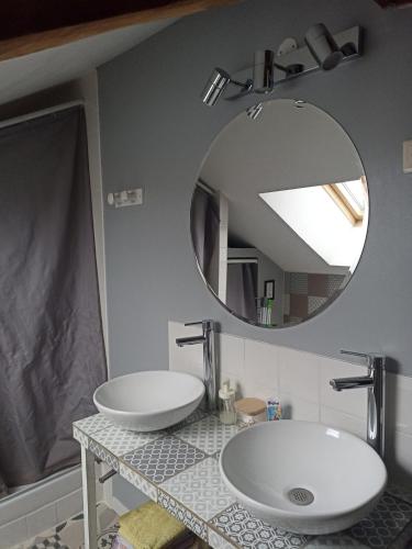 une salle de bain avec deux lavabos et un miroir dans l'établissement Maison de pierre entre golfe et Océan, à Sarzeau