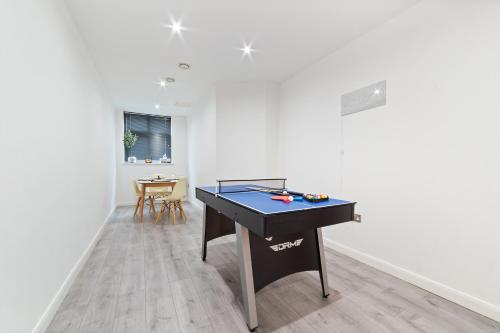 a ping pong table in a room with a table at City Centre Gem - Apartment Sleeps 5 in Leicester