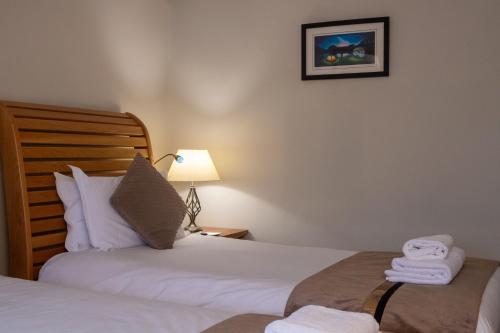 two beds in a bedroom with a lamp and towels at The Frenchgate Bed and Breakfast in Richmond