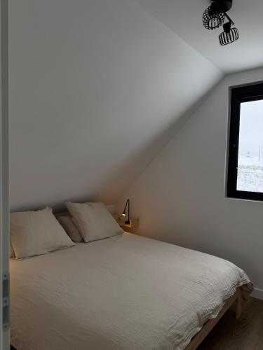 a white bed in a bedroom with a window at Chalet 15 in Saint-Genès-Champespe