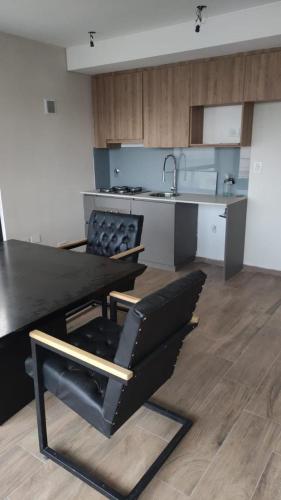 een keuken met een zwarte tafel en een wastafel bij Hermoso Monoambiente lanusita in Lanús
