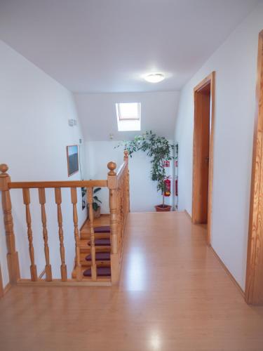 a hallway with a wooden staircase with a wooden floor at PENZION BENEŠOV u BROUMOVA in Broumov