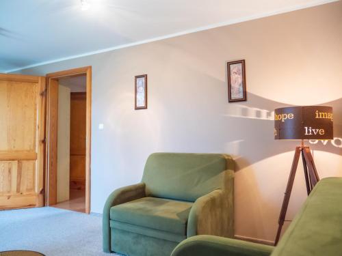 a living room with a green chair and a lamp at PENZION BENEŠOV u BROUMOVA in Broumov