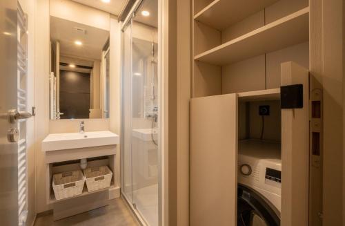 une salle de bain avec un lavabo et une machine à laver dans l'établissement Green Resort Chalet with Clim & Pool, à Ondres
