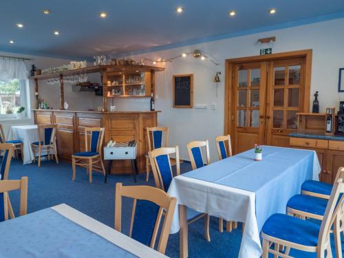a restaurant with tables and chairs and a kitchen at PENZION BENEŠOV u BROUMOVA in Broumov