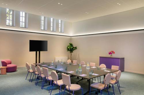 a conference room with a long table and chairs at The Rebyl, Nijmegen, a Tribute Portfolio Hotel in Nijmegen