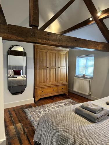 a bedroom with a bed and a dresser and a mirror at The Cottage, Upper Linney, Ludlow in Ludlow
