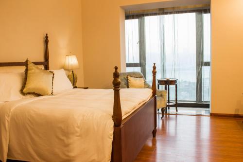 a bedroom with a bed and a large window at Ramada Plaza By Wyndham Fuzhou South in Fuzhou