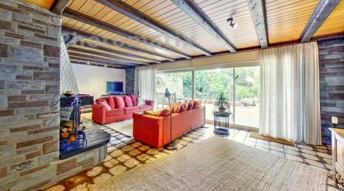 a living room with red furniture and a stone wall at Exklusive Landvilla mit Pool, Sauna und Garten in Schwalmtal