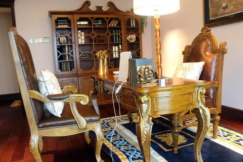 an office with a wooden desk and a chair at Ramada Plaza By Wyndham Fuzhou South in Fuzhou