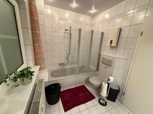 a bathroom with a shower and a toilet and a tub at Charmante Ferienwohnung in Garbsen Stilvoll Geräumig in Garbsen