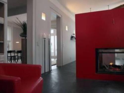 a living room with a red couch and a fireplace at Belle Maison au cœur des alpes in Leysin
