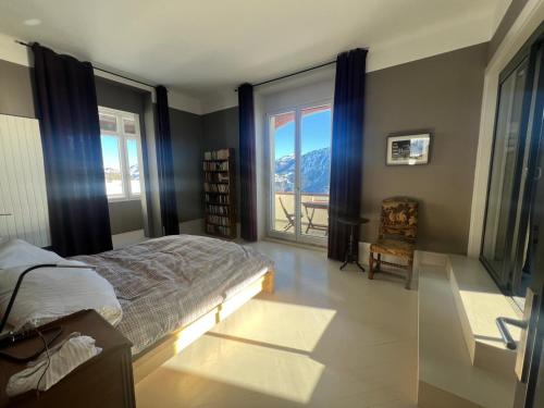 a bedroom with a bed and a view of a mountain at Belle Maison au cœur des alpes in Leysin