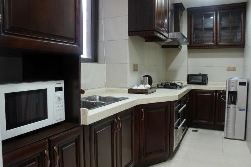 a kitchen with a sink and a microwave at Ramada Plaza By Wyndham Fuzhou South in Fuzhou