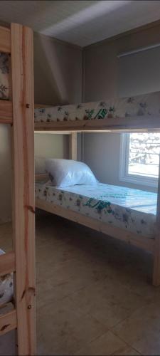 two bunk beds in a room with a window at Cabaña 4 Brisas del Valle in Tafí del Valle