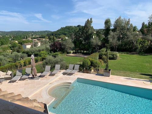 - une piscine avec des chaises et une vue sur le jardin dans l'établissement Paradise in olives grove, à Grasse
