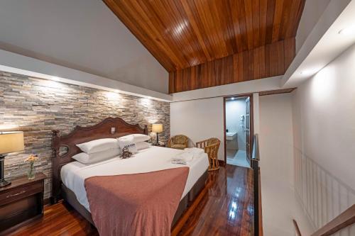 a bedroom with a bed and a brick wall at Hotel Bambito By Faranda Boutique, a member of Radisson Individuals in Cerro Punta