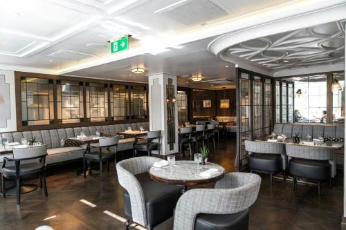a restaurant with tables and chairs in a room at London Marriott Hotel Park Lane in London
