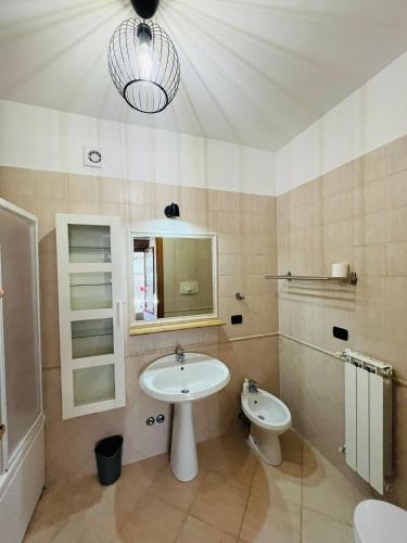 a bathroom with a sink and a toilet and a mirror at Giramondo Guest house in Fiumicino