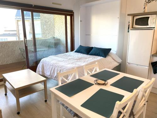 une petite pièce avec un lit, une table et des chaises dans l'établissement Appartement avec balcon, parking, au port de de PERROS-GUIREC - Réf 829, à Perros-Guirec