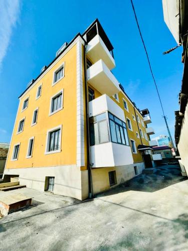 un edificio giallo e bianco sul lato di una strada di Guba Bliss a Quba