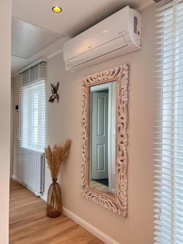 a mirror on a wall with a ceiling fan at Apartment mit Mainblick 15 Min vom FFM-Airport in Flörsheim