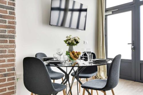 une salle à manger avec une table et des chaises noires dans l'établissement Superb apartment - 1BR 4P - Gare Montparnasse, à Paris