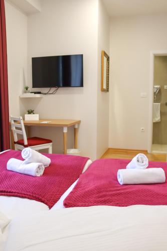 two beds in a hotel room with towels at Boutique Hostel Livia in Metković