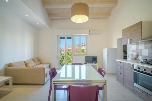 Una cocina y una sala de estar con mesa y sillas. en Talete, appartamento in centro a 40 mt dalla spiaggia - Pomelia, en Marina di Ragusa