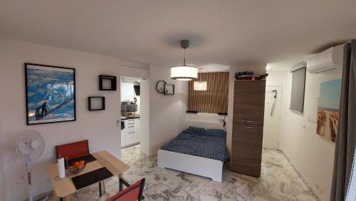 une petite chambre avec un lit et une table dans l'établissement Studio F1 avec jardin, proche du Palais des festivals et des plages, à Cannes
