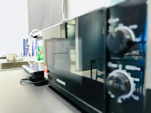 a computer monitor on a counter in a room at Deluxe Suites with Infinity Pool, Kids' Pool & Sea in Jelutong