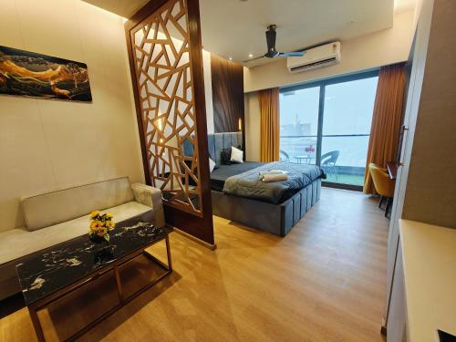a room with a bed and a couch and a mirror at Luxurious suite with City view in Ghaziabad