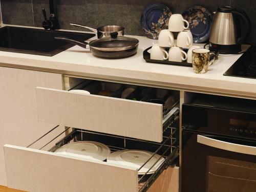 an open drawer in a kitchen with plates and dishes at Luxurious suite with City view in Ghaziabad