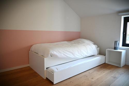 a bedroom with a white bed and two night stands at Le Moulin de Bosson - Ourasi in Ferrières