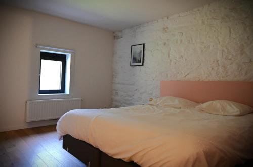 a bedroom with a white bed and a window at Le Moulin de Bosson - Ourasi in Ferrières